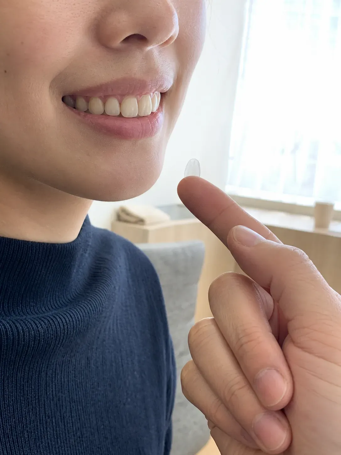 薄いベニアのシェルを口元にかざして確かめるイメージ